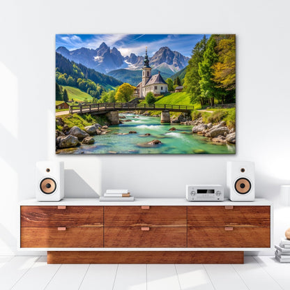 Leinwandbild Alpenidylle mit Kirche, Brücke und türkisblauem Bach. - deyoli