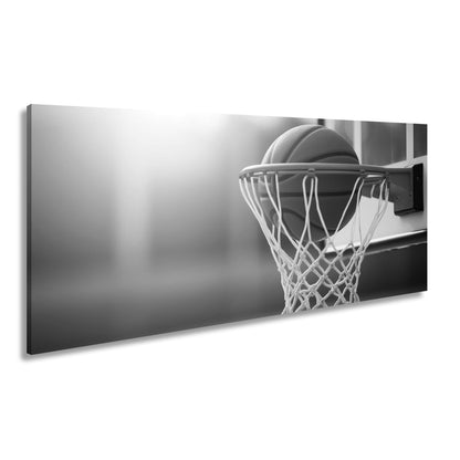 Leinwandbild Basketball versinkt elegant im Korb im sanften Licht. - deyoli