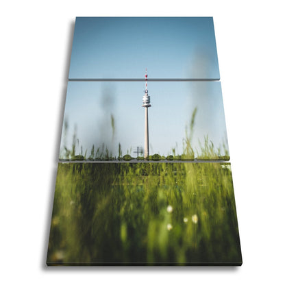Leinwandbild Donauturm über Wiese im klaren Sommerhimmel XXL – Wien Wahrzeichen - deyoli