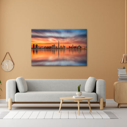 Leinwandbild Dubai XXL – Skyline spiegelt im glühenden Abendhimmel - deyoli