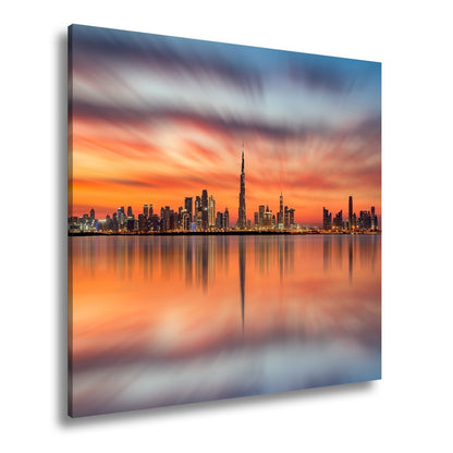 Leinwandbild Dubai XXL – Skyline spiegelt im glühenden Abendhimmel - deyoli