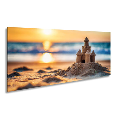 Leinwandbild Ein Sandburgtraum glüht im goldenen Licht des Sonnenuntergangs. - deyoli