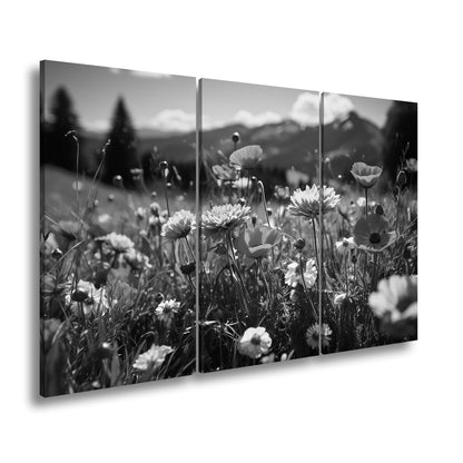 Leinwandbild Farbenfrohe Wiesenblumen tanzen vor Bergkulisse. - deyoli