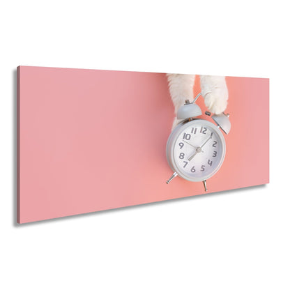 Leinwandbild Flauschige Pfoten halten die Zeit auf rosa Grund. - deyoli