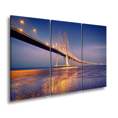 Leinwandbild Goldenes Leuchten über Brücke bei ruhigem Abendmeer XXL – Landschaft - deyoli