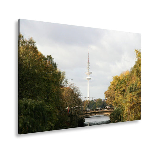 Leinwandbild Hamburg XXL – Goldene Alsterbrücke unter herbstlichen Bäumen mit Funkturm - deyoli
