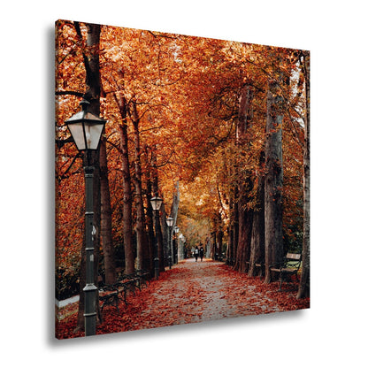Leinwandbild Herbstfarben tanzen über einen romantischen Laubweg. - deyoli