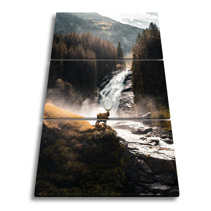 Leinwandbild Hirsch vor tosender Wasserfallkulisse - deyoli
