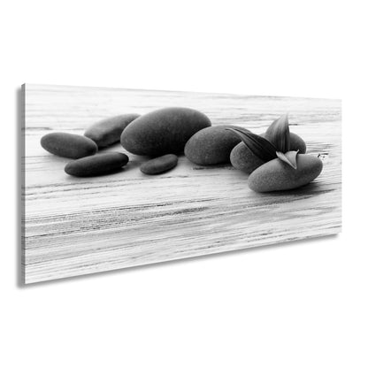 Leinwandbild Schwarze Steine, grünes Blatt – Ruhe auf weißem Holz. - deyoli