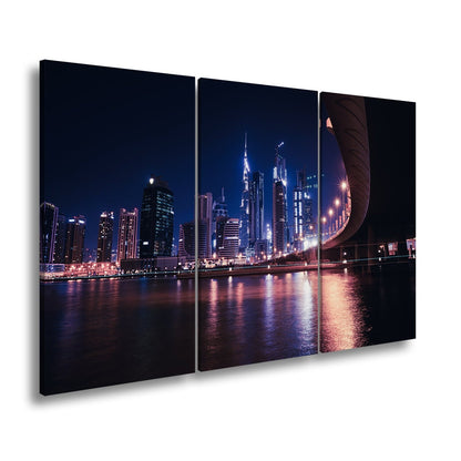 Leinwandbild Skyline XXL – Nächtlich spiegelt in violetten Lichtern - deyoli