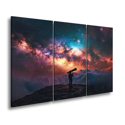 Leinwandbild Sternenbeobachter vor leuchtender Galaxie über den Wolken - deyoli