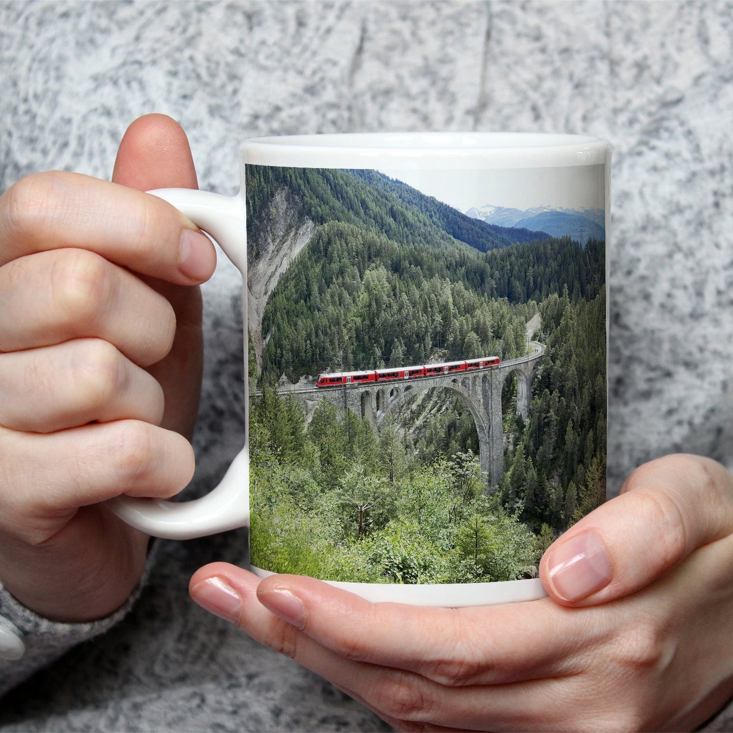 Motivtasse Ein roter Zug schwebt über ein grünes Meer aus Tannen. - deyoli