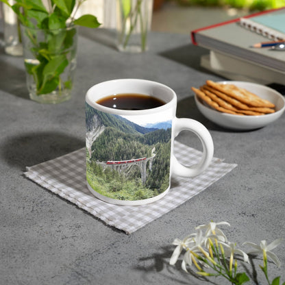 Motivtasse Ein roter Zug schwebt über ein grünes Meer aus Tannen. - deyoli