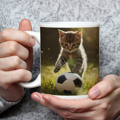 Motivtasse Katzenkick – flauschiger Fußballspaß im Sonnenlicht. - deyoli