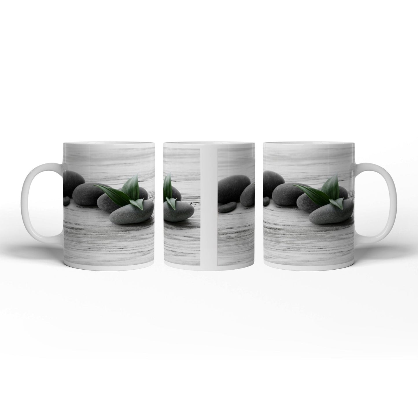Motivtasse Schwarze Steine, grünes Blatt – Ruhe auf weißem Holz. - deyoli