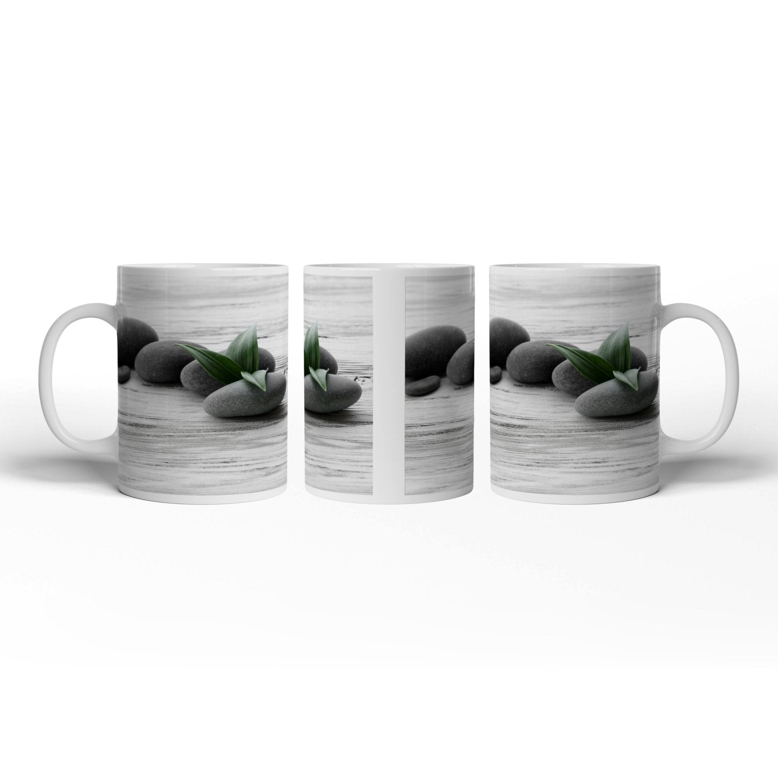 Motivtasse Schwarze Steine, grünes Blatt – Ruhe auf weißem Holz. - deyoli