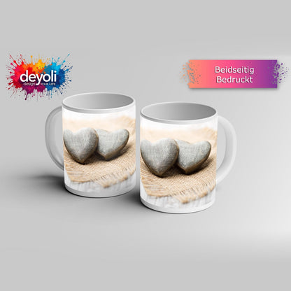 Motivtasse Zwei Steinherzen ruhen auf sanftem Leinengewebe. - deyoli