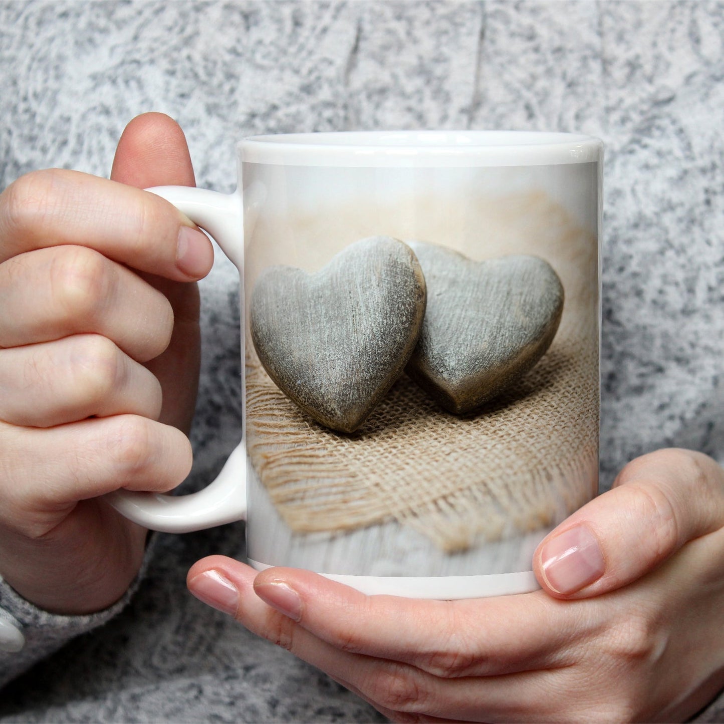 Motivtasse Zwei Steinherzen ruhen auf sanftem Leinengewebe. - deyoli