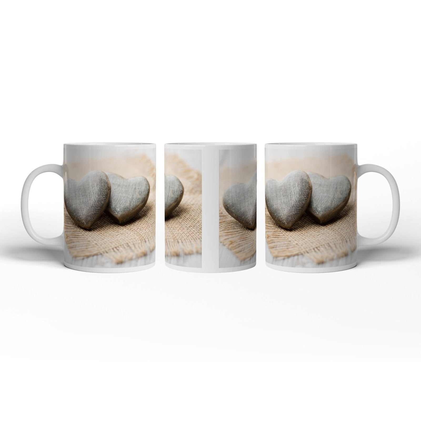 Motivtasse Zwei Steinherzen ruhen auf sanftem Leinengewebe. - deyoli